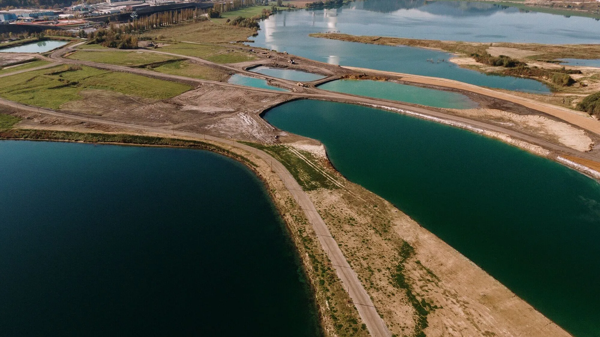 Pegada Hídrica.| Imagem sobre bacias hidrograficas. Nesta fotografia há um rio com águas em tons de azul escruo, um céu azul e algumas vegetações e tons de verde e marrom claro.