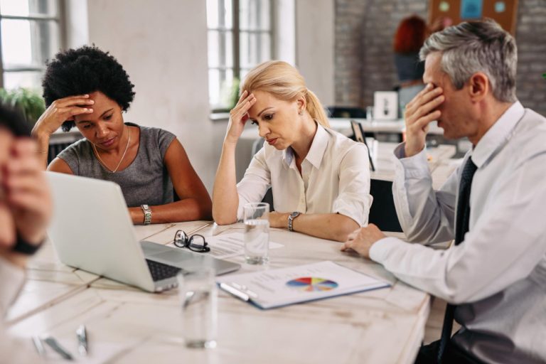 Grupo de colegas de trabalho com dor de cabeça enquanto trabalhava